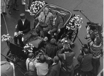 After the announcement of the Nobel Prize, a carriage drives Paul Crutzen and his wife to the Max Planck Institute in 1995. Image: MPI for Chemistry A black-and-white photo showing a carriage from above. Two people are sitting in the back of the carriage, and one person is sitting on the driver's seat in the front. The carriage is surrounded by journalists with cameras.