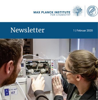 Two people examine and adjust a complex electronic device in a laboratory setting.