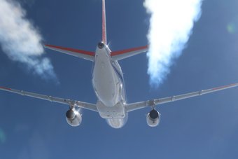 In 2018 joint flight tests conducted by DLR and NASA clearly demonstrated that fewer soot particles from sustainable fuels in exhaust result in fewer ice crystals in contrails. Aircraft from behind, blue sky, white streams of exhaust on the left and right