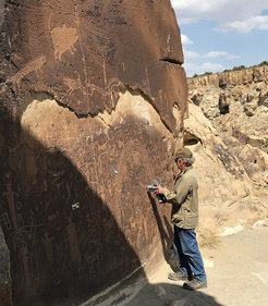 Meinrat O. Andreae takes measurements on the rock varnish using a portable X-ray fluorescence device.
Photo: Tracey W. Andreae, MPI for Chemistry