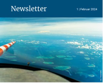 Aerial perspective showing scattered islands in turquoise water, partially obscured by clouds, under a vast blue sky.