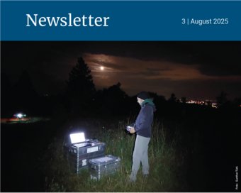 Eine Person arbeitet nachts auf einem Feld mit einem Laptop, während der Vollmond den Himmel erhellt.